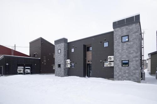 a building with snow in front of it at Niseko Town Retreat ONYX in Kutchan