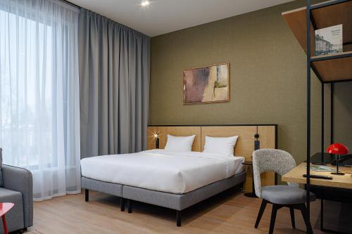 a hotel room with a bed and a desk at TULIP Residences Lviv in Lviv