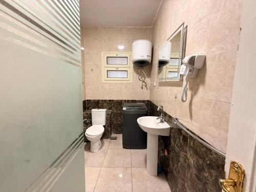 a small bathroom with a toilet and a sink at Moon Homes in Downtown Cairo in Cairo