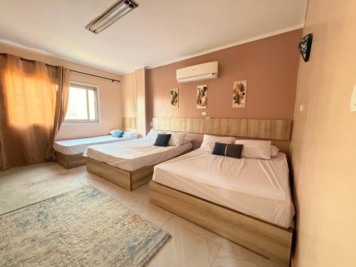 a bedroom with two beds and a rug at Moon Homes in Downtown Cairo in Cairo