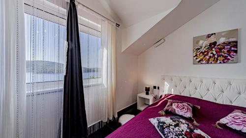 a bedroom with a purple bed and a window at Villa Franka by Villas Guide in Vela Luka
