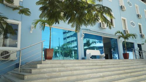 un edificio con escaleras y palmeras delante en Hotel Americas, en Fortaleza