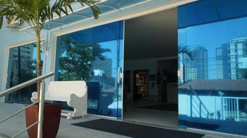 an open glass door of a building with a palm tree at Hotel Americas in Fortaleza