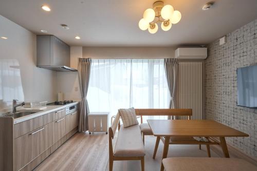 a kitchen with a table and a dining room at Niseko Town Retreat AMBER in Kutchan