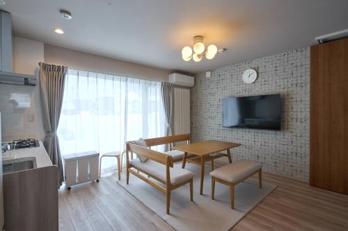 a living room with a table and chairs and a kitchen at Niseko Town Retreat AMBER in Kutchan