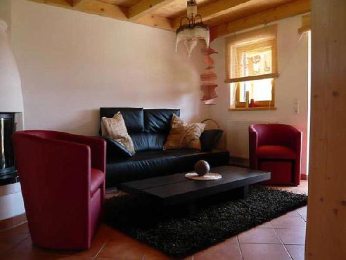 a living room with a couch and a coffee table at Meisters Ferienhaus in Lechbruck