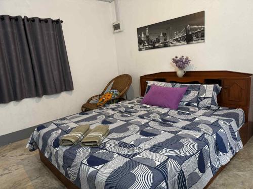 a bedroom with a bed with two slippers on it at Baboo Studio in Chiang Dao