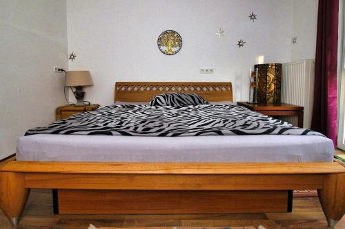 a bed in a bedroom with a zebra print sheets at Haus Hönigblick in Wilnsdorf