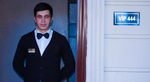 a man in a tuxedo standing next to a door at Vilesh Palace Hotel in Masallı