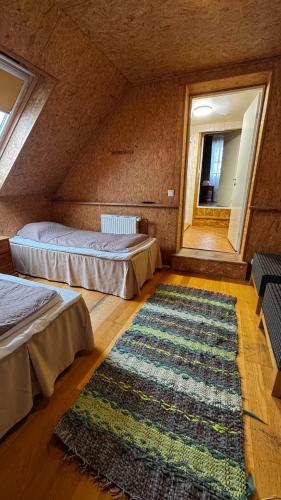 a room with two beds and a rug on the floor at Nõiariik Holiday Village in Antsla