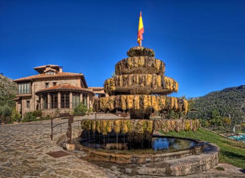 a fountain in front of a house with a building at Coto del Valle de Cazorla in Cazorla