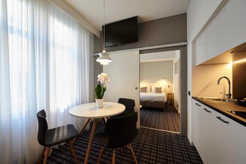 a hotel room with a table and chairs and a bed at Leopold Hotel Ostend in Ostend