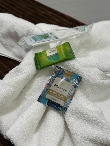 a package of toothpaste and a tube of toothpaste on a towel at Suíte Cavalos - Queen's Hotel in Formosa