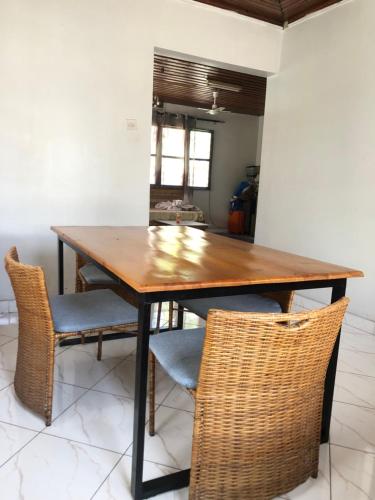 a dining room table with two chairs and a table at The Nest Haven Hostel in Dar es Salaam