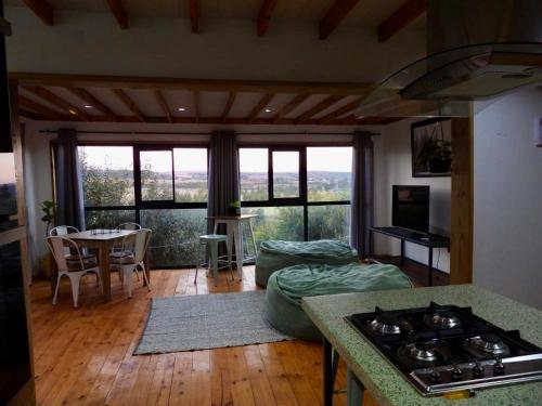 a kitchen and living room with a stove and a table at Black Sunbird Retreat in Heidelberg