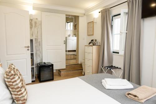 a bedroom with a white bed and a bathroom at Inn Bairro Alto BA Sweet in Lisbon