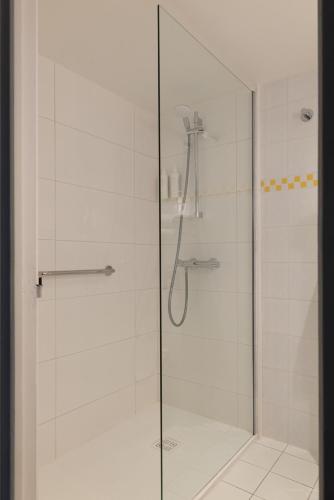 eine Duschkabine mit Glasduschtür in der Unterkunft Hôtel Le Colisée in Paris