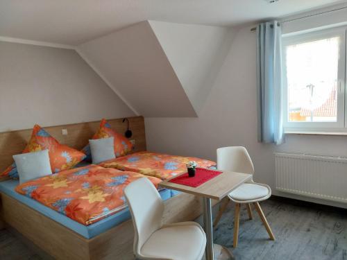 a bedroom with a bed and a table and chairs at Pension Edelstein in Ostseebad Sellin