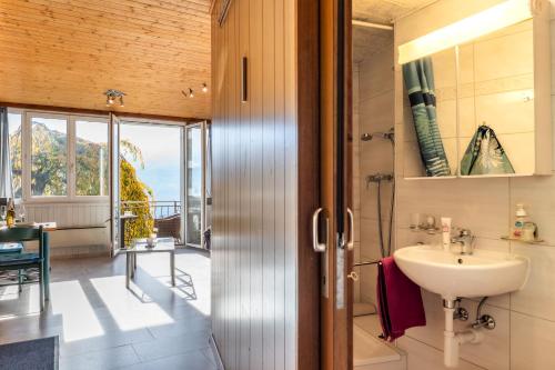 a bathroom with a sink and a view of a balcony at Casa Sybille, beautiful lake view in Minusio