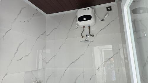 a white bathroom with a camera on the wall at Probosiwi Resort Syariah in Talunombo