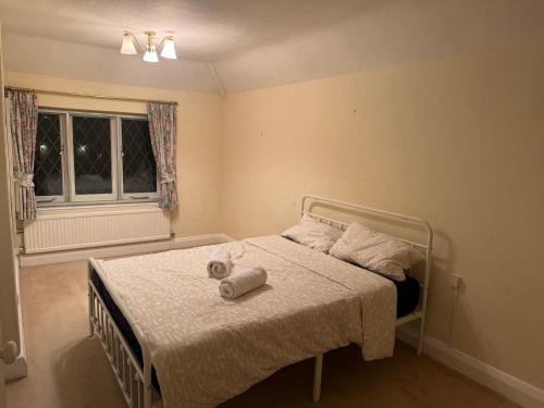 a bedroom with a bed with two towels on it at The Sweet Spot in Ickenham