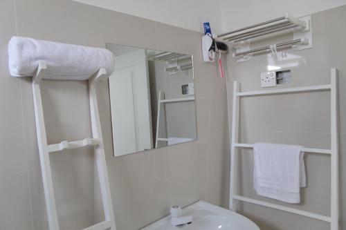 Un baño con un lavabo blanco y un espejo. en White Villa Ambalangoda, en Ambalangoda