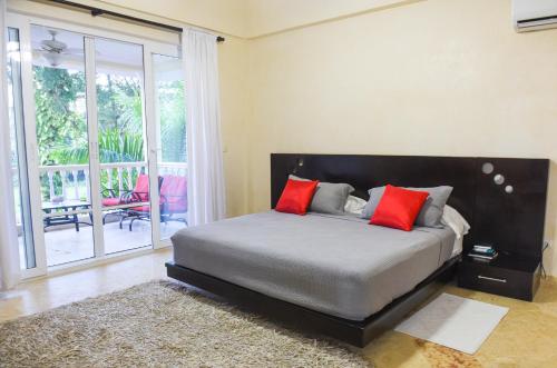 Un dormitorio con una cama con almohadas rojas. en Hispaniola Luxury Ocean Front Condo en Sosúa