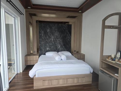 a bedroom with a large bed with white pillows at Probosiwi Resort Syariah in Talunombo