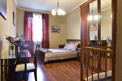 a bedroom with a bed and a table and a chair at Tbilisi Art Apartment in Tbilisi City