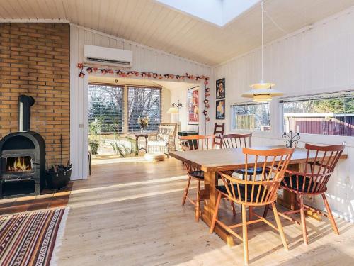 a dining room with a table and a fireplace at 4 person holiday home in Vejby in Vejby