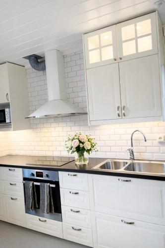 a kitchen with white cabinets and a sink at Annie Järdebergsgatan 3 in Kiruna
