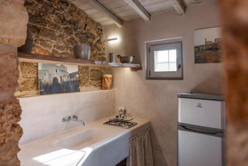 a small kitchen with a sink and a stove at Masseria De Li Travaj - Rive del Salento in Patù
