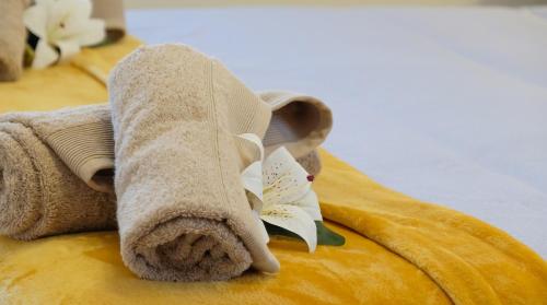 a towel with a flower on it sitting on a bed at APARTAMETO BAZTANGOA I Centro Elizondo in Elizondo