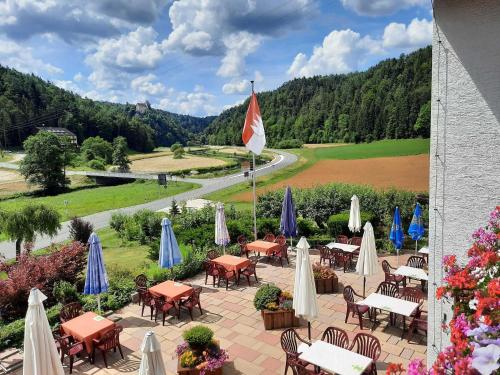 a patio with tables and chairs and umbrellas at Café-Pension Krems in Waischenfeld