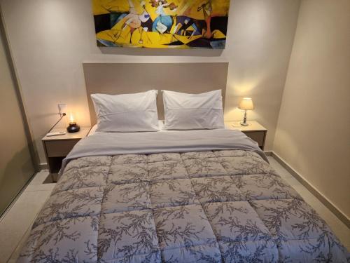 a bedroom with a bed and two tables with lamps at Skoza farm house in Nárkissos