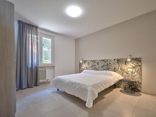a bedroom with a bed and a large window at Residence Green Park in Torri del Benaco