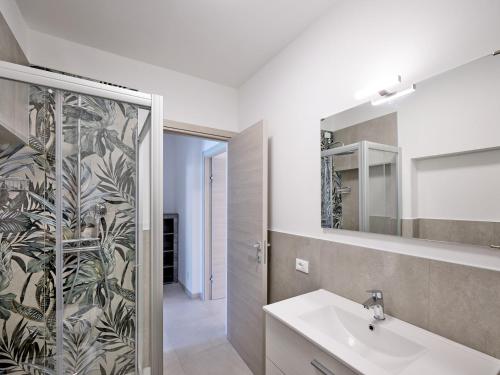 a bathroom with a sink and a shower with a mirror at Residence Green Park in Torri del Benaco