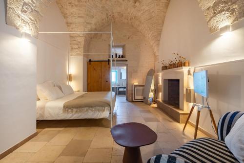a bedroom with a bed and a fireplace at Masseria Valentina in Ostuni