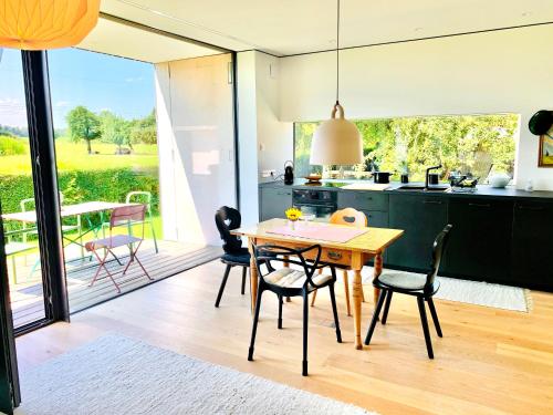 una cucina e una sala da pranzo con tavolo e sedie di simsseeLOFT - Ferienapartments in Baierbach am Simssee a Stephanskirchen