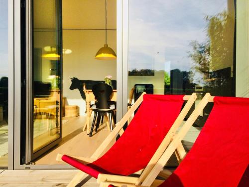un paio di sedie sedute su un balcone di simsseeLOFT - Ferienapartments in Baierbach am Simssee a Stephanskirchen