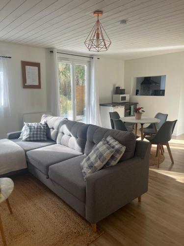 a living room with a gray couch and a table at Lamaisondubois31 in Pibrac