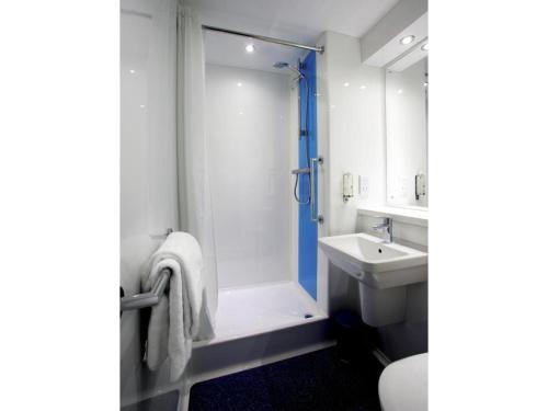 a bathroom with a shower and a toilet and a sink at Travelodge Widnes in Widnes