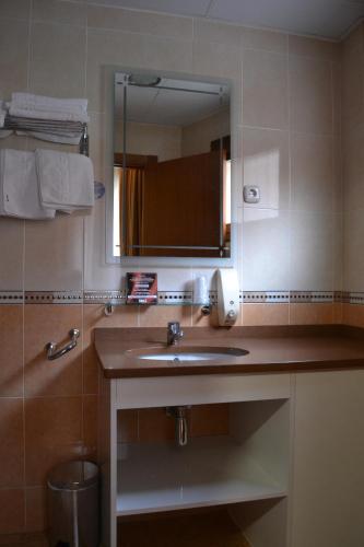 a bathroom with a sink and a mirror at Hostal Restaurante El Castillo in Alcorisa