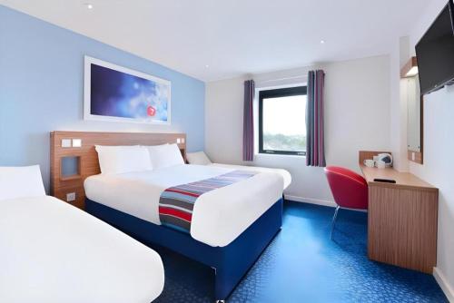 a hotel room with two beds and a tv at Travelodge Middlesbrough in Middlesbrough
