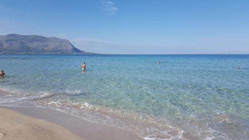 a group of people in the water at the beach at Arricàmpati Airport Rooms & Bringo Car Rental in Carini