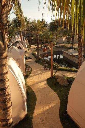 a pathway next to a resort with palm trees at The Silkroad Mũi Né in Ấp Khánh Phước (1)