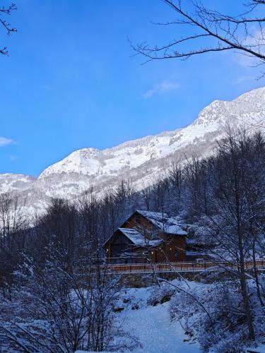 a cabin in the snow with mountains in the background at Boga Chalet in Bogë