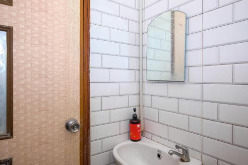 a bathroom with a sink and a mirror at RedDoorz @ Soekarno Hatta 2 in Malang