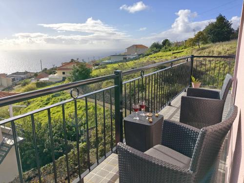 a balcony with a table and chairs and the ocean at Golden Sun Refugio -Calheta in Estreito da Calheta