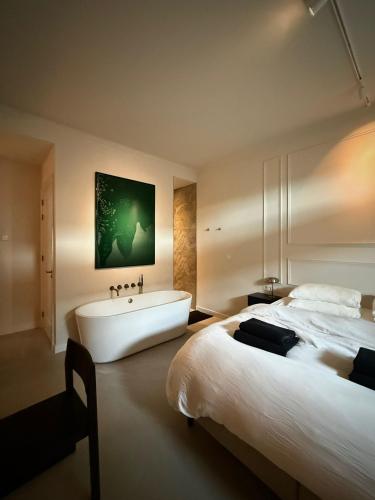 ein Schlafzimmer mit einem großen Bett und einer Badewanne in der Unterkunft TEAM bnb in De Koog